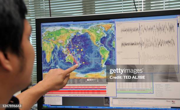 Philippine seismologist Winchelle Sevilla points to a map and seismograph of an earthquake which struck New Zealand earlier in the day, during a...