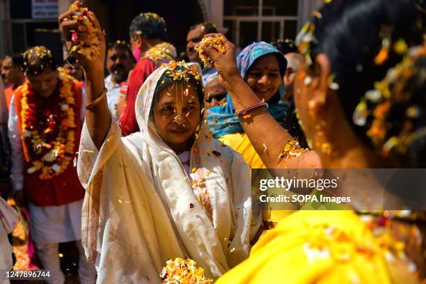 Indian Widows throw colorful flower petals during a celebration of Holi or 'festival of colors' at Gopinath Temple in Vrindavan. Indian widows, break...