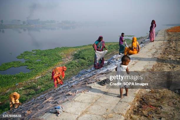 Laborers seen arranging leather hides on the ground for drying at a tannery factory on the bank of the polluted river Dhaleswari at Saver outskirt of...