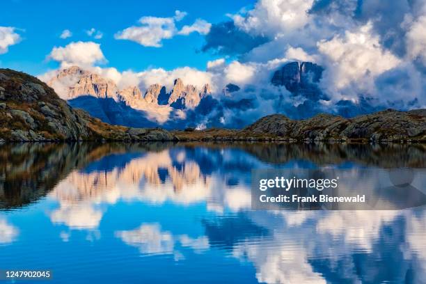 The main range of Brenta Dolomites, partially shrouded in storm clouds, reflected in the lake Lago Nero. The entire Brenta Dolomites are part of the...