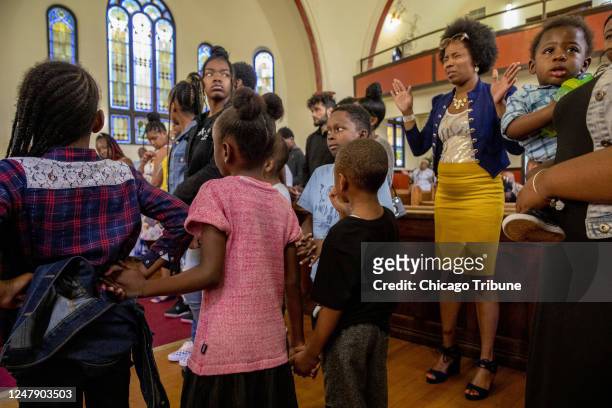 People at Apostolic House of Prayer Church in Chicago&apos;s Back of the Yards neighborhood pray during a memorial service for witness Treja Kelley a...