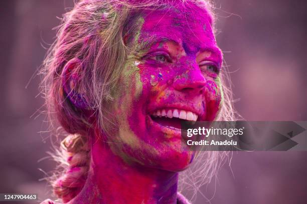 Revellers daubed in Gulal or coloured powder dance as they celebrate Holi Festival on March 8, 2023 in Guwahati, India. Holi is the Hindu festival of...