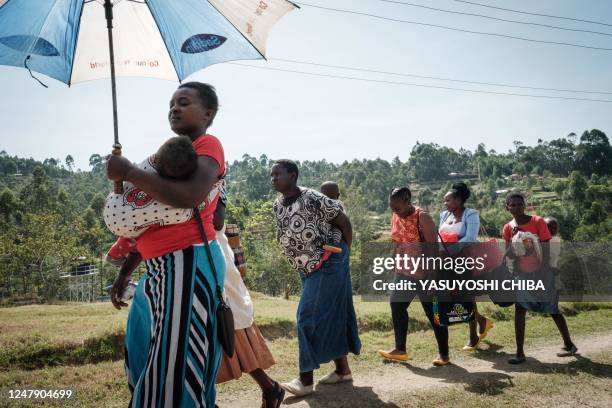 Mothers walk to attend the launch of the extension of the worlds first malaria vaccine pilot program for children at risk of malaria illness and...