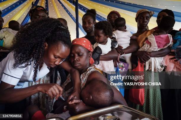 Child receives a shot during the launch of the extension of the worlds first malaria vaccine pilot program for children at risk of malaria illness...