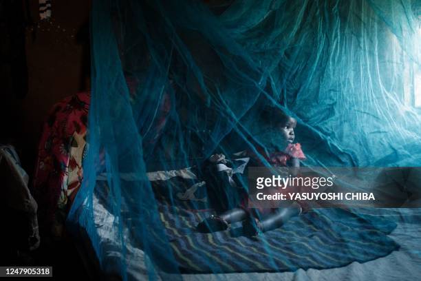 Ruth Kavere demonstrates to use a mosquito net with her granddaughter Faith who completed doses through the worlds first malaria vaccine pilot...