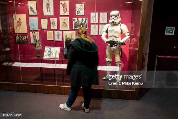 Visitor beside a costume of a Storm Trooper from the film Star Wars in the Theatre & Perfomance galleries at the V&A aka Victoria and Albert Museum...