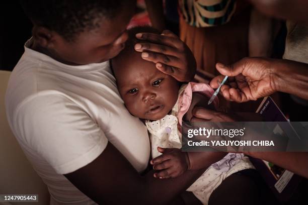 Child receives a shot during the launch of the extension of the worlds first malaria vaccine pilot program for children at risk of malaria illness...