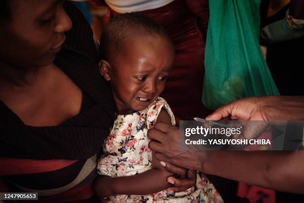 Child receives a shot during the launch of the extension of the worlds first malaria vaccine pilot program for children at risk of malaria illness...