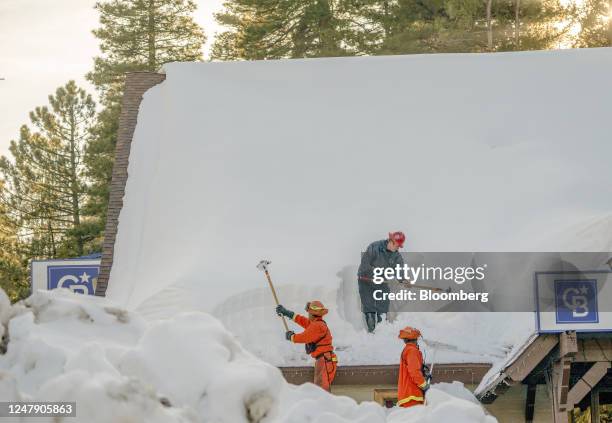 Inmate firefighters clear snow from the roof of a business in Lake Arrowhead, California, US, on Tuesday, March 7, 2023. The San Bernardino Mountains...