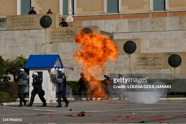 Molotov cocktail explodes near Greek riot police guarding the Greek parliament during a nationwide day of mass strikes and protests over the...