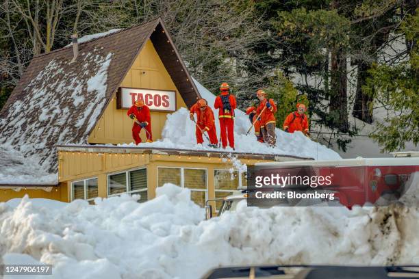 Inmate firefighters clear snow off the roof of a restaurant in Lake Arrowhead, California, US, on Tuesday, March 7, 2023. The San Bernardino...