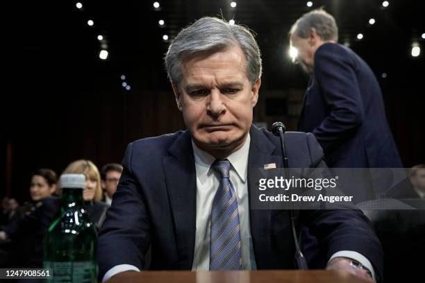 Director Christopher Wray takes his seat as he arrives for a Senate Intelligence Committee hearing concerning worldwide threats, on Capitol Hill...