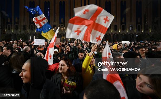 Protesters take part in a demonstration called by Georgian opposition and civil society groups outside Georgia's Parliament in Tbilisi on March 8,...