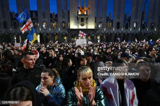 Protesters take part in a demonstration called by Georgian opposition and civil society groups outside Georgia's Parliament in Tbilisi on March 8,...