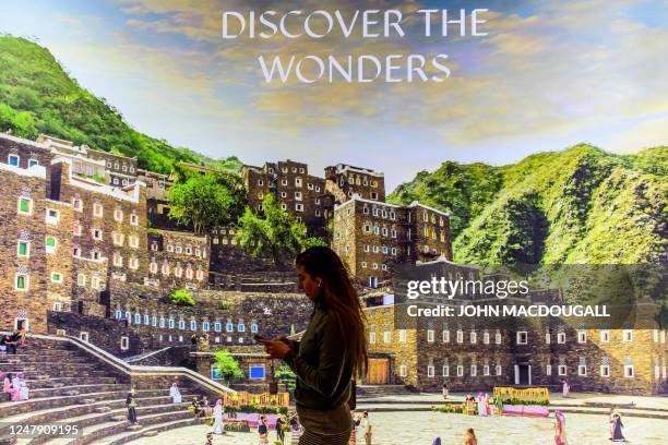 Visitor walks past a billboard at the Saudi Arabia stand at the International Tourism Trade Fair in Berlin on March 8, 2023. - The world's largest...