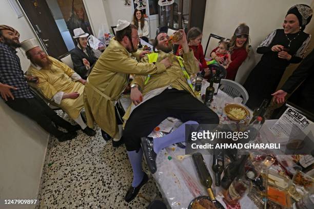 Ultra-Orthodox Jews celebrate Purim in Jerusalem's Mea Shearim neighbourhood, on March 8, 2023. - The carnival-like Purim holiday is celebrated with...