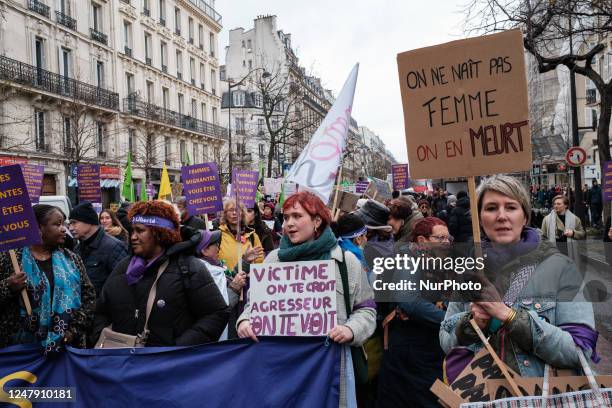 Woman holds a placard which reads as ''you are not born a woman, you die a woman'' as she takes part in a rally to mark the International Women's Day...