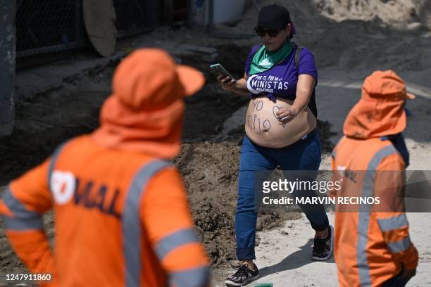 Pregnant woman takes part in a march in support of women's rights in San Salvador on March 8 on International Women's Day.