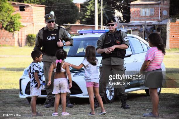 Children chat with members of Argentina's Gendarmerie patrolling at the neighbourhood of "Los Pumitas" in the north of Rosario, Santa Fe, Argentina...