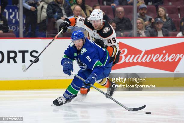 Vancouver Canucks center J.T. Miller and Anaheim Ducks left wing Max Jones battle for the puck during their NHL game at Rogers Arena on March 8, 2023...