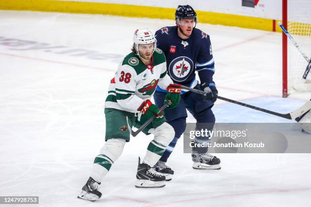 Ryan Hartman of the Minnesota Wild and Nate Schmidt of the Winnipeg Jets keep an eye on the play during third period action at the Canada Life Centre...