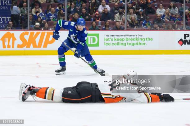 Vancouver Canucks defenseman Christian Wolanin skates with the puck as Anaheim Ducks defenceman Nathan Beaulieu slides on the ice during their NHL...