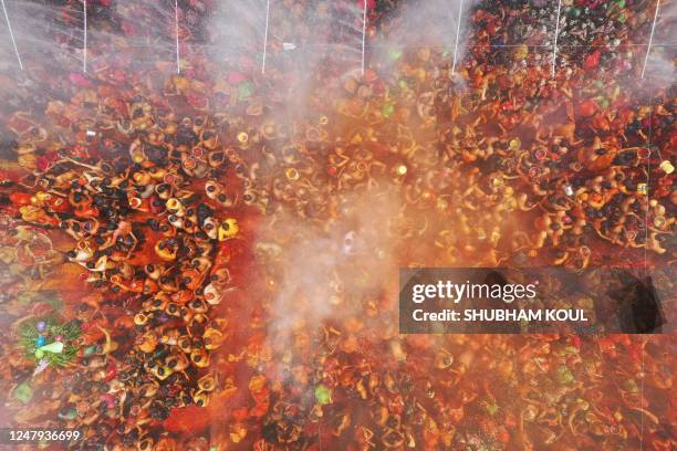 An aerial view shows revellers smeared with 'Gulal' or coloured powder as they celebrate Holi, the Hindu spring festival of colours, at Dauji temple...
