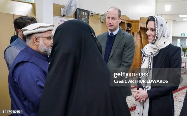 Britain's Prince William, Prince of Wales and Britain's Catherine, Princess of Wales speak to members of the community as they visit the Hayes Muslim...