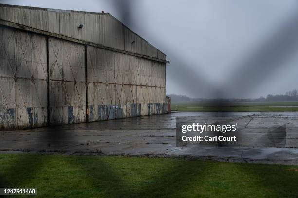 Disused aircraft hangar is pictured behind the perimeter fence at MDP Wethersfield, a former Royal Air Force base, on March 9, 2023 in Wethersfield,...