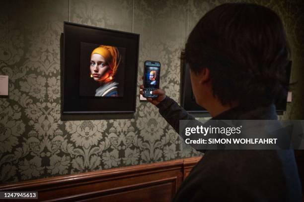 Visitor takes a picture with his mobile phone of an image designed with artificial intelligence by Berlin-based digital creator Julian van Dieken...