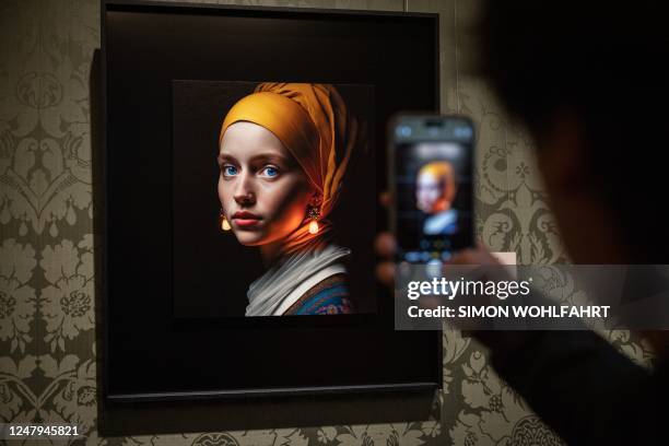 Visitor takes a picture with his mobile phone of an image designed with artificial intelligence by Berlin-based digital creator Julian van Dieken...