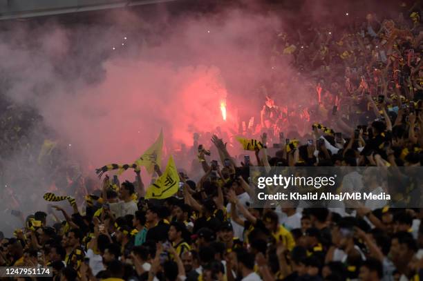 Al Ittihad fans celebrate and set off flares after their sides first goal during the Saudi Pro League match between Al Ittihad and Al Nassr at King...