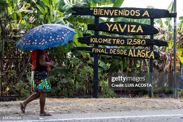 Woman walks by a welcome sign at Yaviza town, Darien Province in Panama, on March 9, 2023. - Yaviza marks the site where the Pan-American highway is...