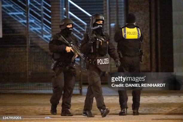 Police stand outside a Jehovah's Witnesses church where several people have been killed in a shooting in Hamburg, northern Germany, on late March 9,...