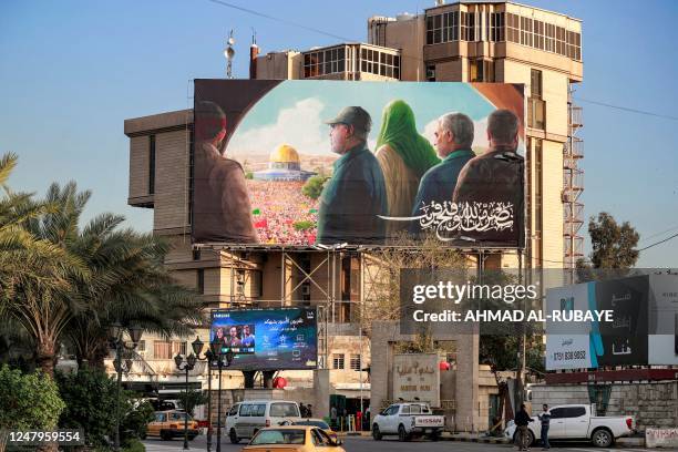 Vehicles drive along al-Firdous square in Baghdad on March 9, 2023 with a prominent billboard showing the slain head of Iran's Islamic Revolutionary...