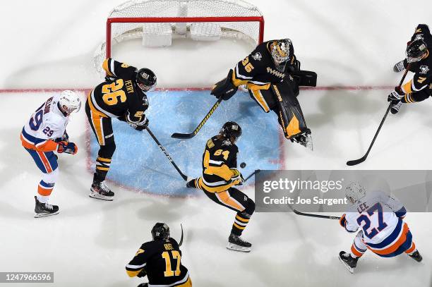 Tristan Jarry of the Pittsburgh Penguins protects the net against Anders Lee of the New York Islanders at PPG PAINTS Arena on March 9, 2023 in...