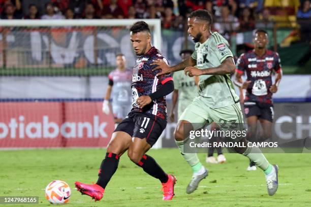Alajuelense Sports League's Alexander Lopez goes for the ball against Los Angeles Futbol Club's Kellyn Acosta during the Champions League match of...