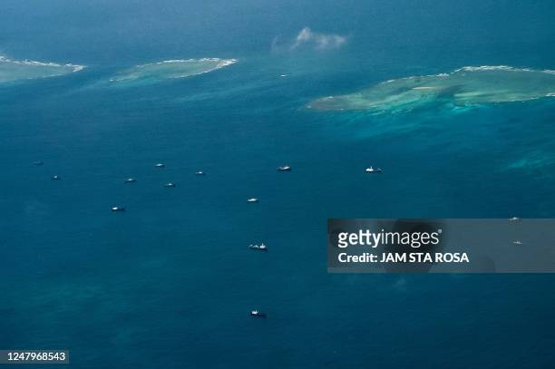 An aerial view taken on March 9, 2023 shows vessels identified by the Philippine Coast Guard as Chinese maritime militia vessels near Thitu Island in...