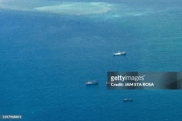 An aerial view taken on March 9, 2023 shows vessels identified by the Philippine Coast Guard as Chinese maritime militia vessels near Thitu Island in...