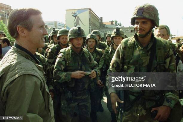 Secretary of Defense William Cohen talks with US troops as he visits the village of Urosevac, south of Pristina 19 June 1999. Cohen spent the day...