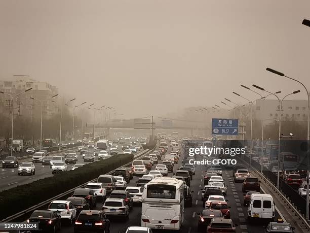 Traffic flows along the West Fourth Ring Road in smog on March 10, 2023 in Beijing, China. Sand and dust weather hit Beijing on the same day.