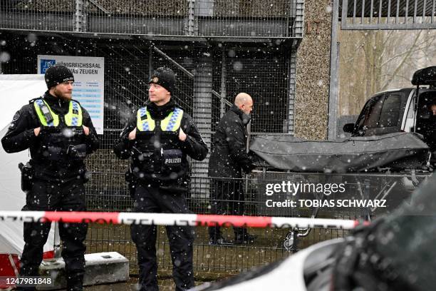 Police stand behind a cordon as the body of one of the victims is taken away at site where several people were killed in a church in a shooting the...