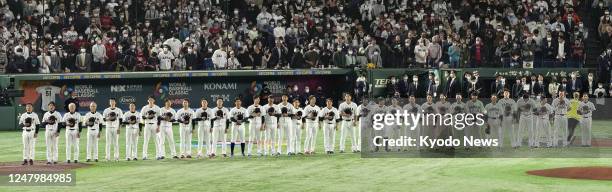 Members of Japan's national baseball team line up on the field for a pregame ceremony ahead of their World Baseball Classic Pool B game against South...