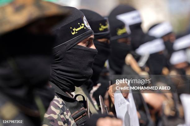 Armed Hamas movement militants take part in a rally to denounce the killing of Palestinians by the Israeli army in West Bank and to support...