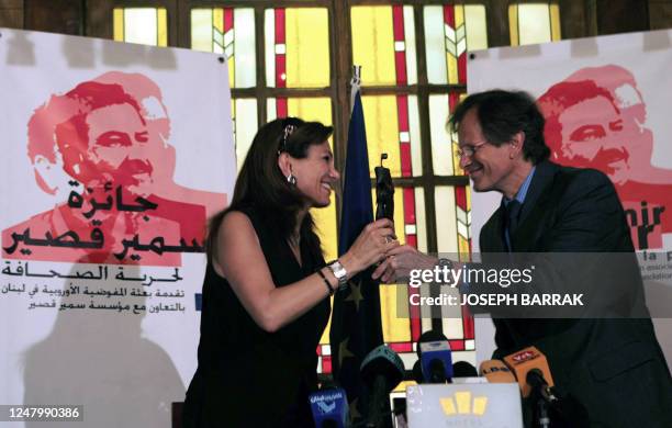 Journalist Gisele Khoury accepts an award from EU ammbassador to Lebanon Patrick Renauld 02 June 2006 during a ceremoney to present the first...