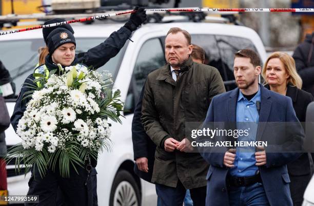 Policeman lifts a police cordon to let through German Interior Minister Nancy Faeser and Hamburg's Interior Senator Andy Grote at the tatort where...