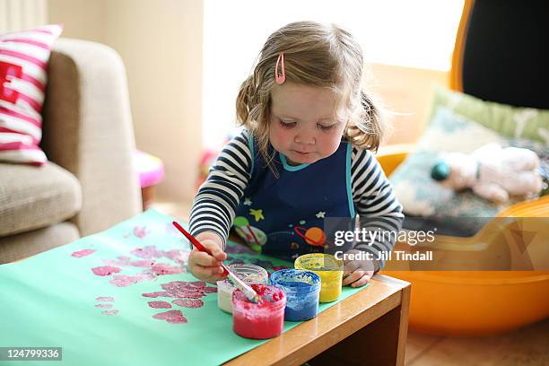 toddler girl painting at home - baby paint stock-fotos und bilder