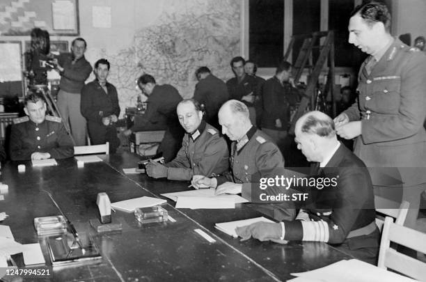 German General Alfred Jodl , flanked by Admiral Von Friedeburg , signs 07 May 1945 the German surrender document at the Allied headquarters in Reims,...