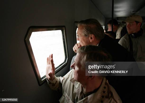 Defense Secretary Donald Rumsfeld and Chairman of the Joint Chiefs, General Richard Myers , look at Iraqi detainees at the Abu Ghraib Prison, 30 kms...