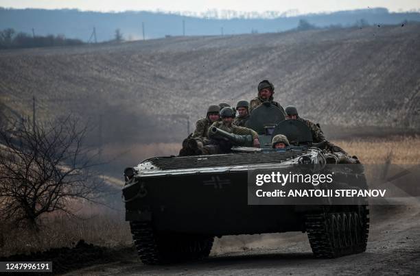 Ukrainian servicemen ride atop a tank near the frontline city of Bakhmut on March 10 amid Russia's military invasion Ukraine.